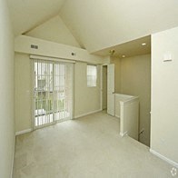 an empty living room with a sliding glass door