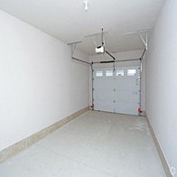 the inside of a garage with a white wall and a garage door