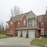 a large brick house with three garage doors