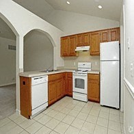 a kitchen with white appliances and wooden cabinets