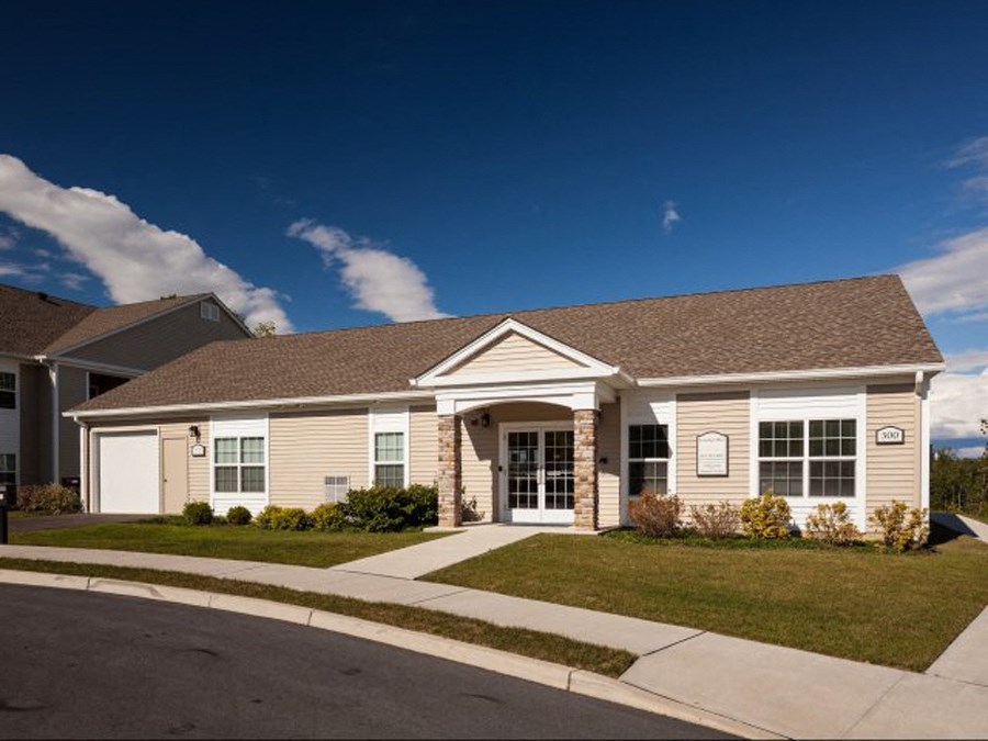 a house with a driveway and lawn in front of it