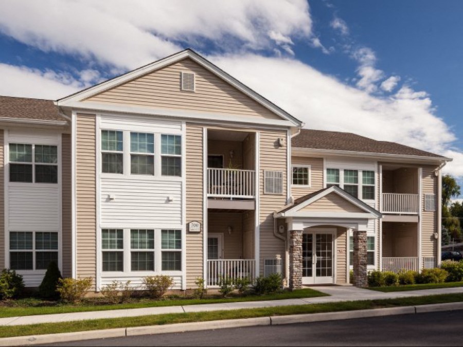 an apartment building with two stories and a balcony