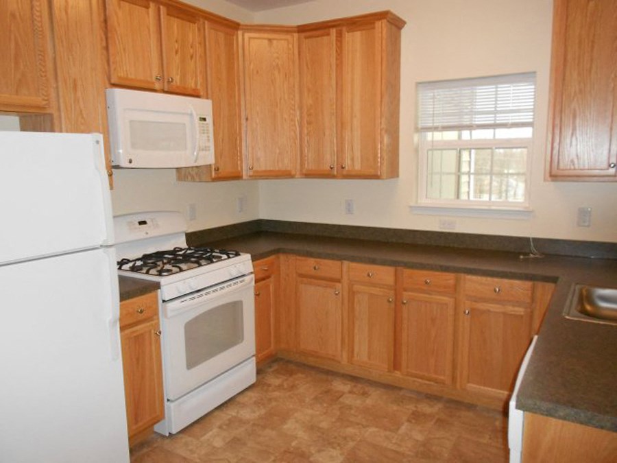 a kitchen with white appliances and wooden cabinets