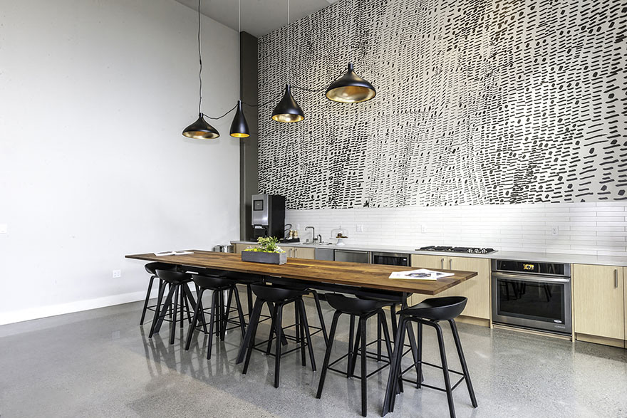 A kitchen with a table and chairs and pendant lights.