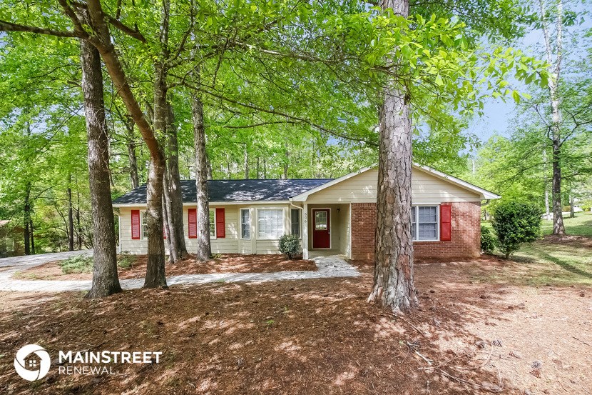 a small house in the woods with trees