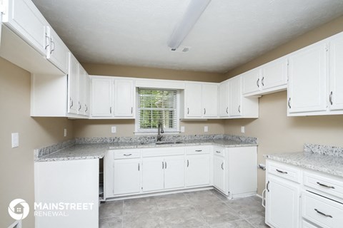 a white kitchen with white cabinets and granite counter tops