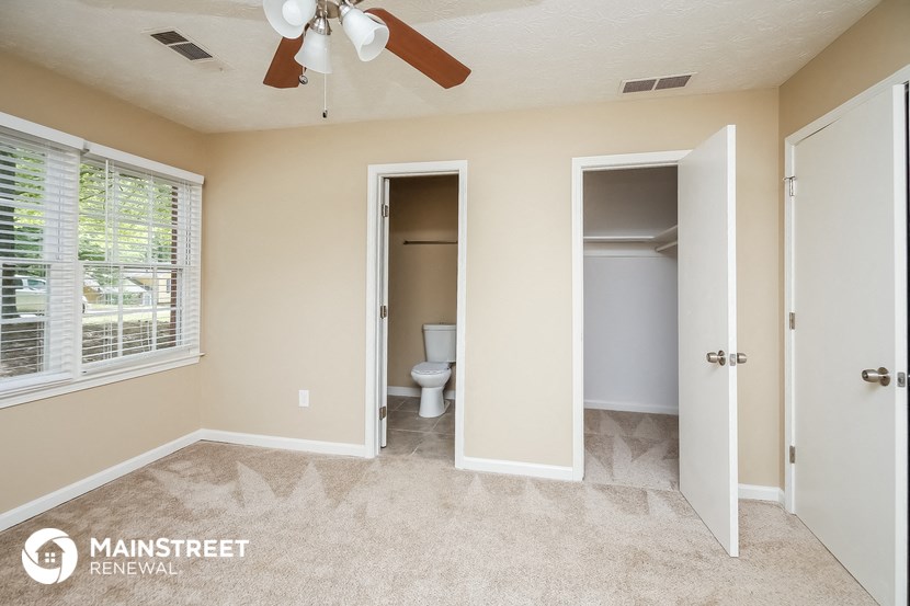 a bedroom with a closet and a bathroom with a toilet