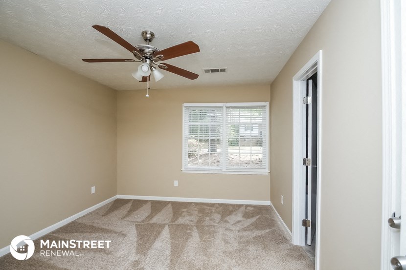 the master bedroom has a ceiling fan and carpeted flooring