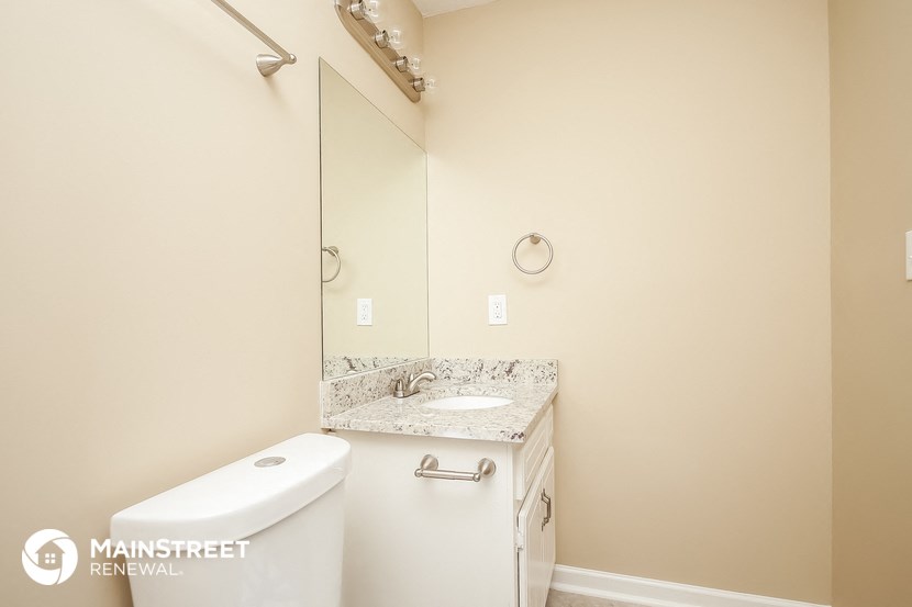 a bathroom with a toilet and a sink and a mirror