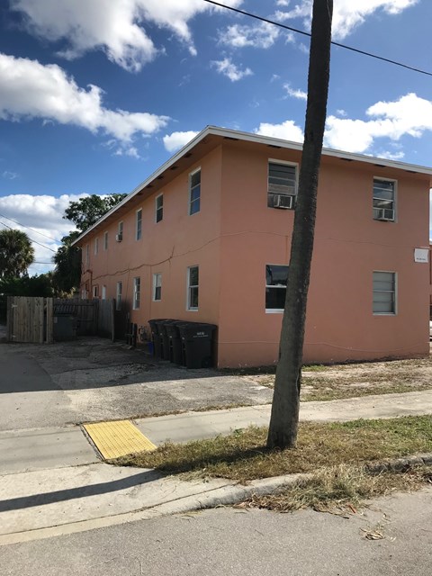 A pink building with a tree in front of it.