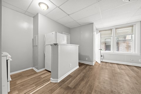 an empty room with a refrigerator and a window