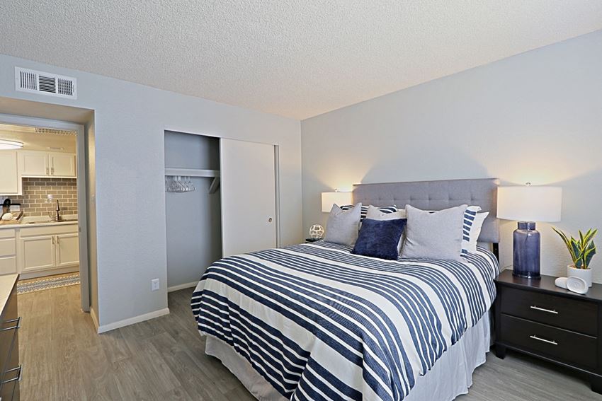 a bedroom with a large bed and a kitchen