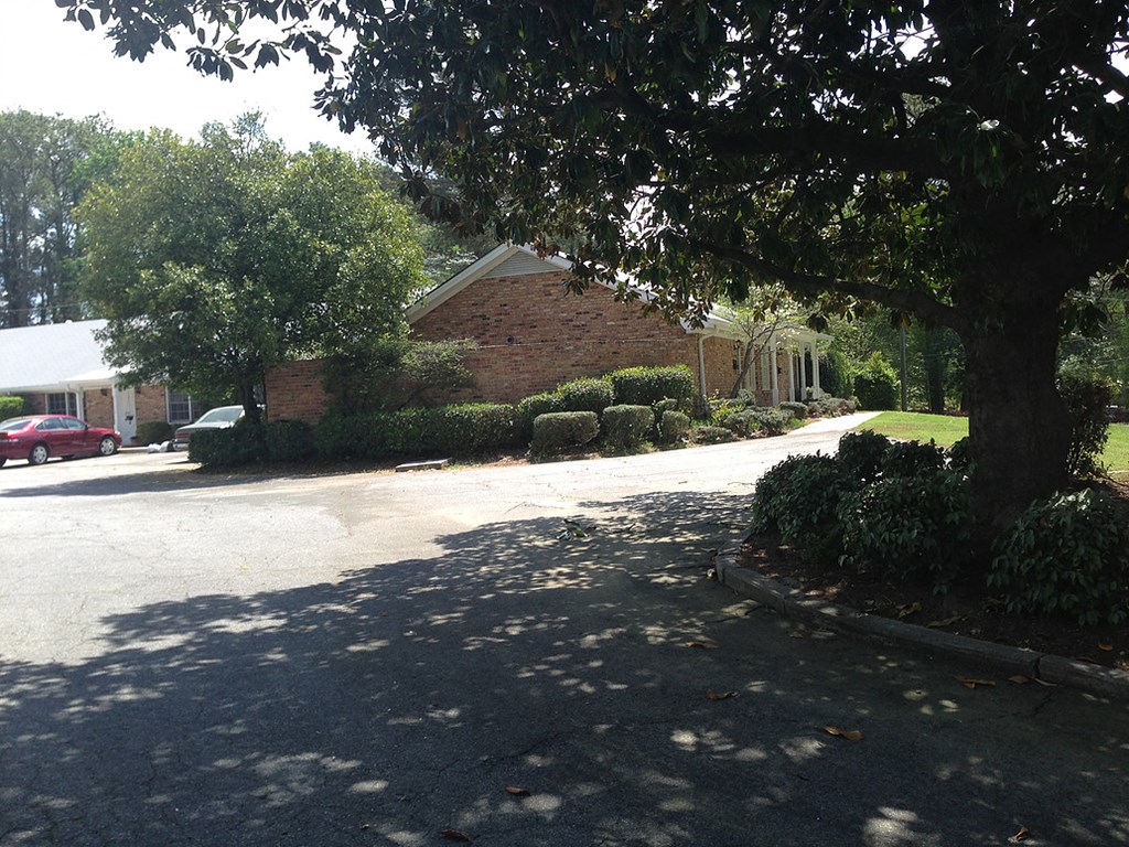 a street in front of a house with a tree