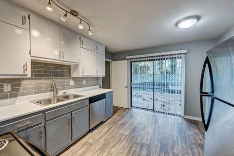 a kitchen with stainless steel appliances and a sliding glass door