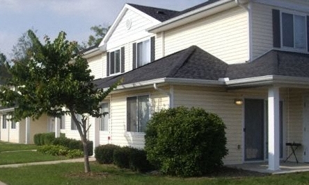 a white house with a tree in front of it