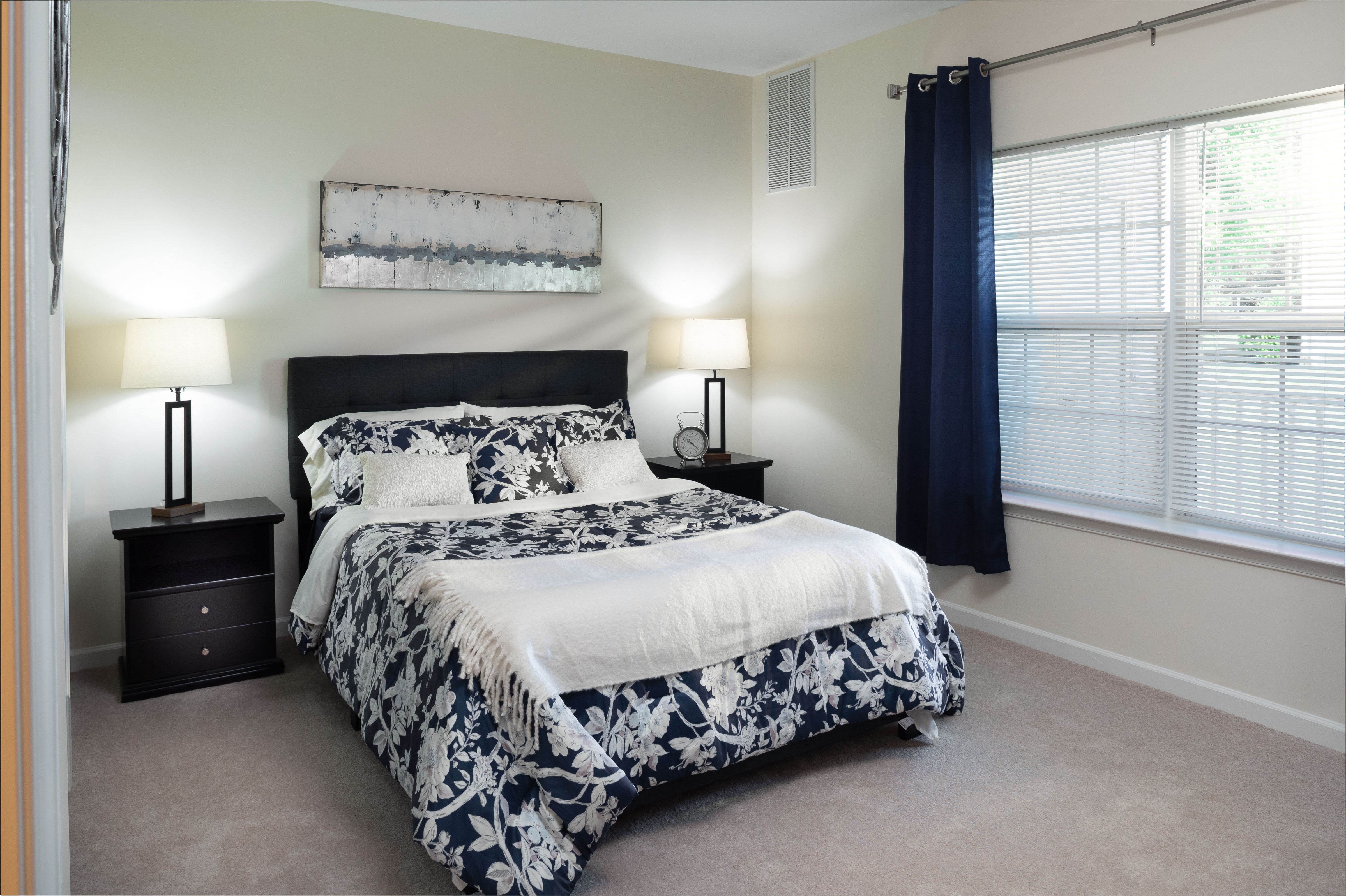 a bedroom with a bed and two night stands and a window