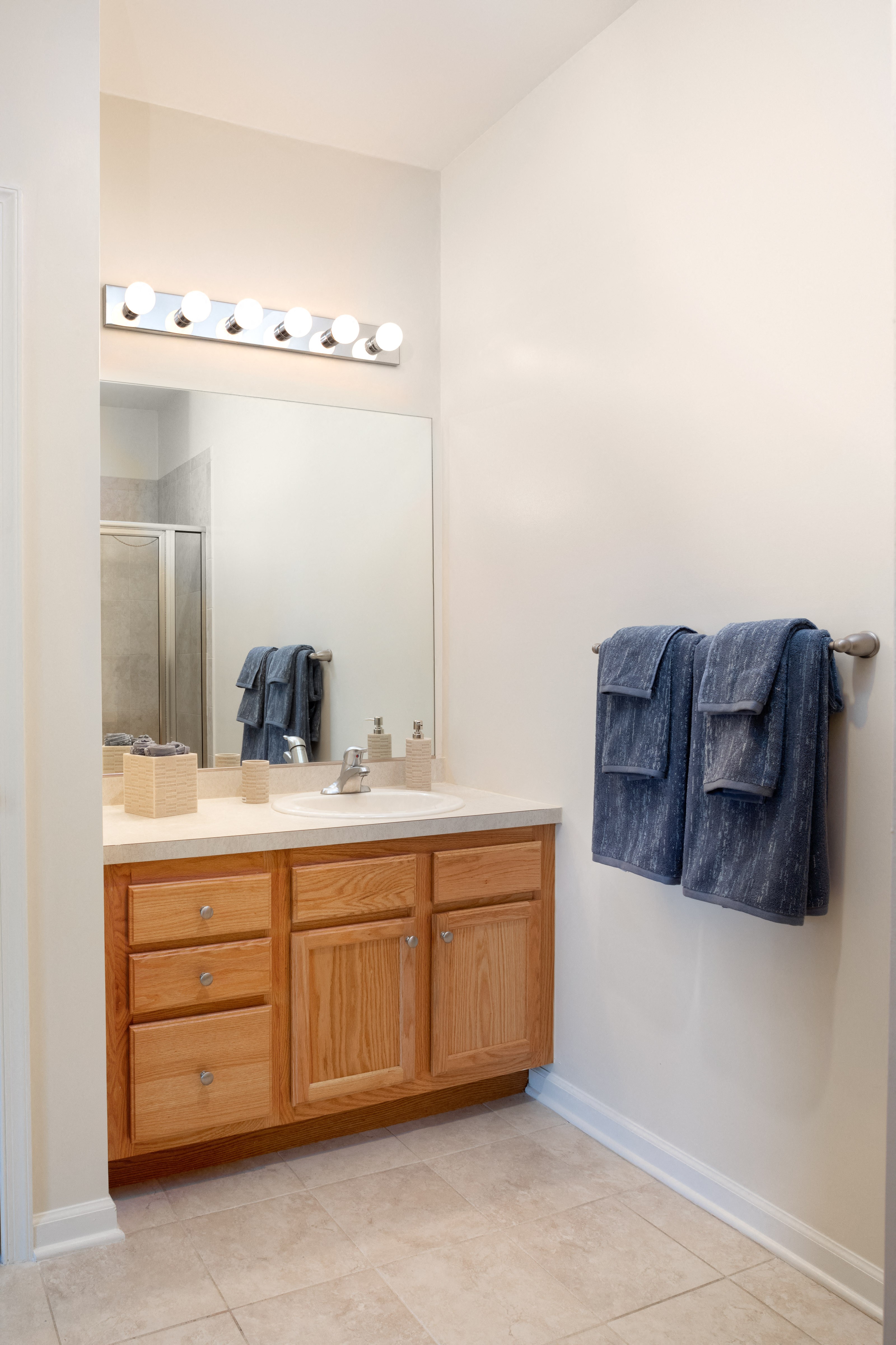 a bathroom with a sink and mirror and blue towels