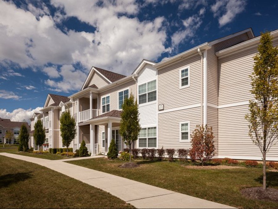 an apartment building with a sidewalk in front of it