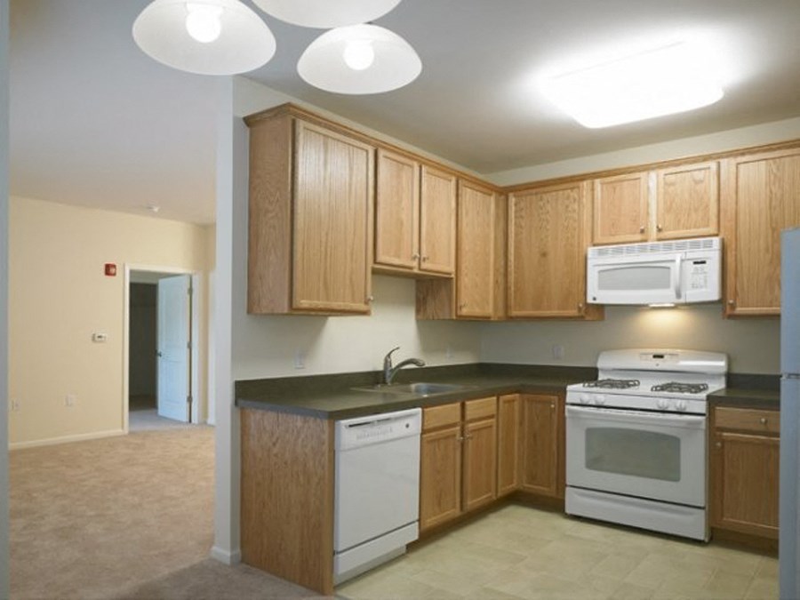 a kitchen with white appliances and wooden cabinets