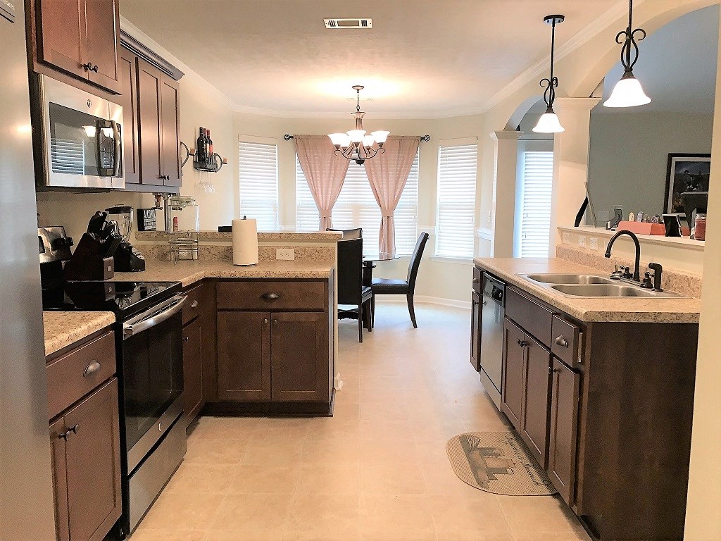 a kitchen and dining room with wood cabinets and stainless steel appliances