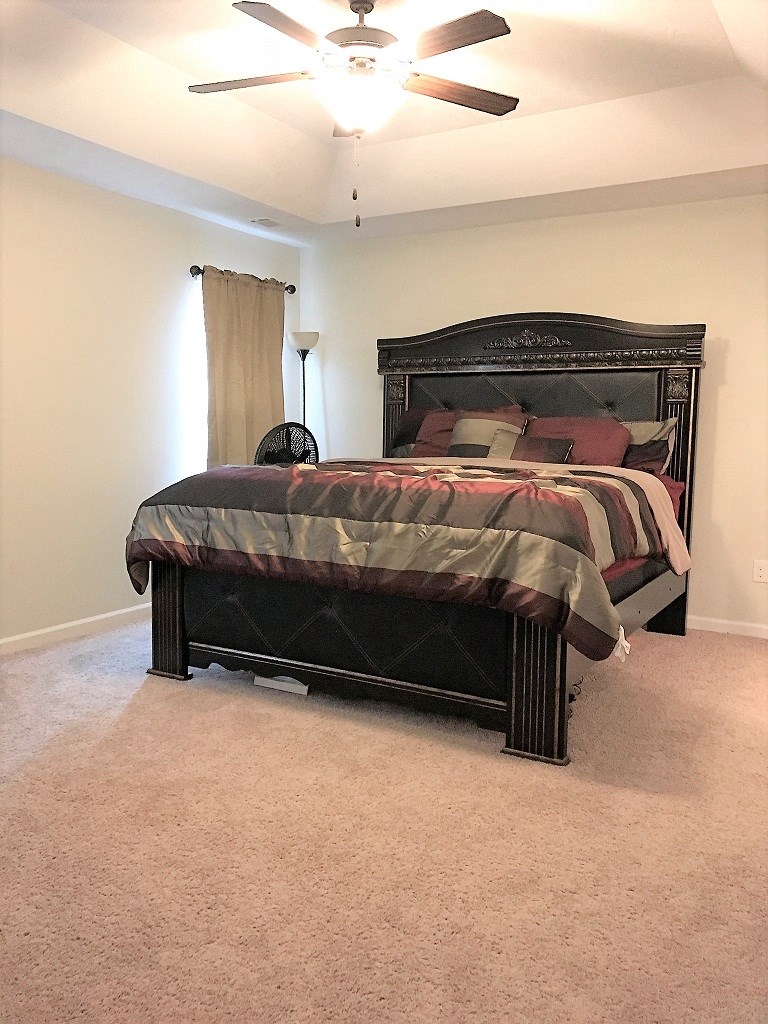 a bedroom with a bed and a ceiling fan