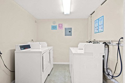 a laundry room with four washes and three dryers in it