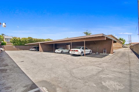 a parking lot with two cars in front of a building