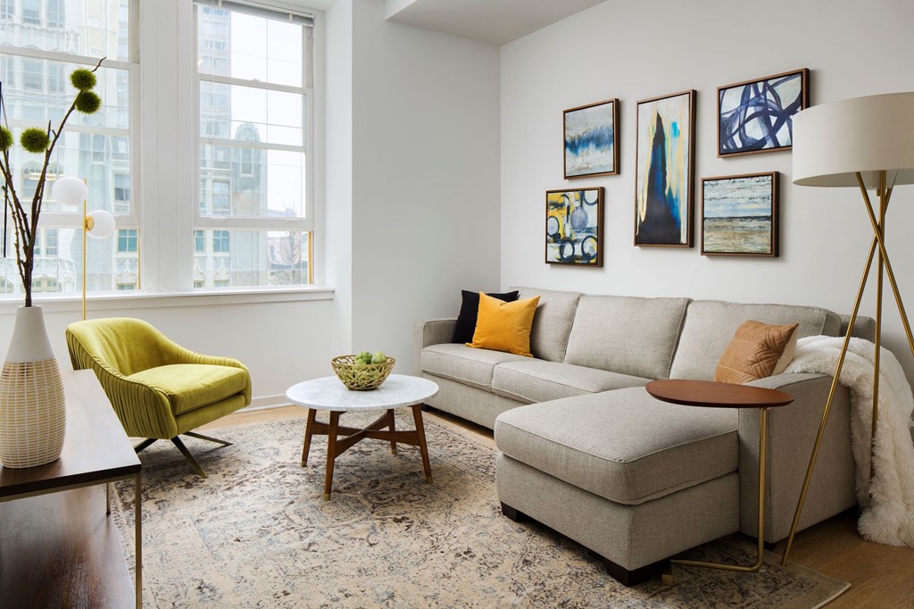 a living room with a gray couch and a yellow chair