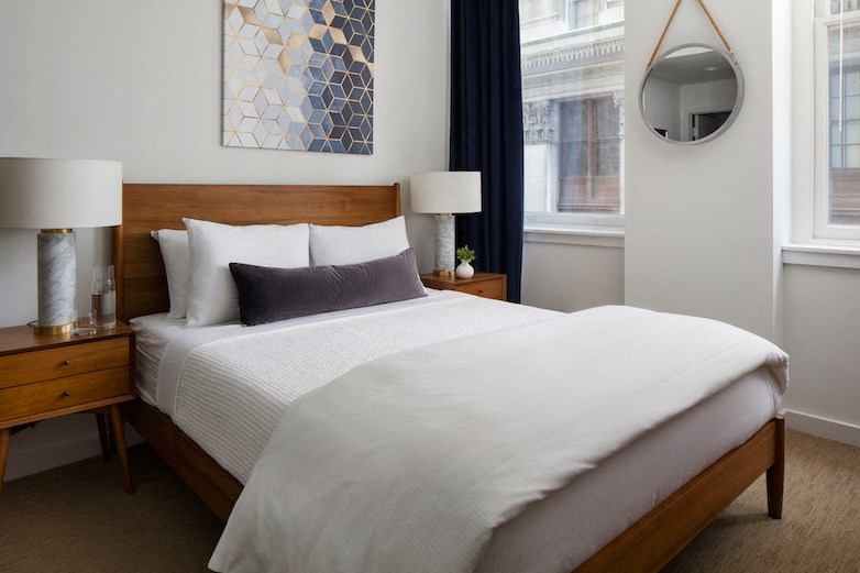 a bedroom with a bed and two windows