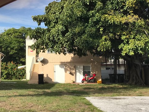 a small house with a red motorcycle parked outside