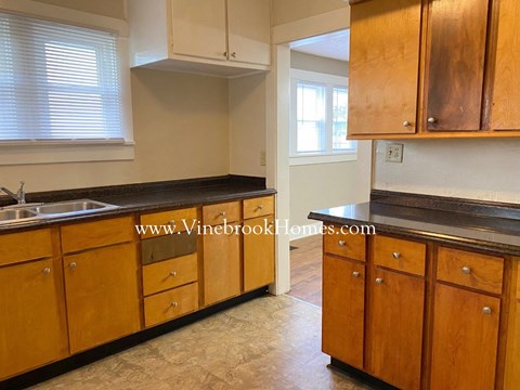 a kitchen with wooden cabinets and a sink and a window