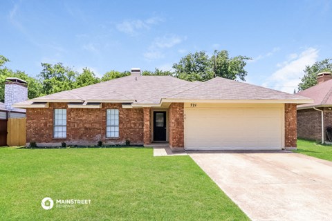 a brick house with a lawn and a garage door