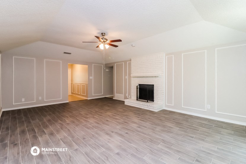 a living room with a fireplace and a ceiling fan
