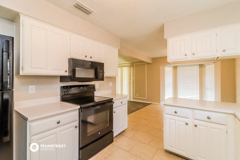 a kitchen with black appliances and white cabinets