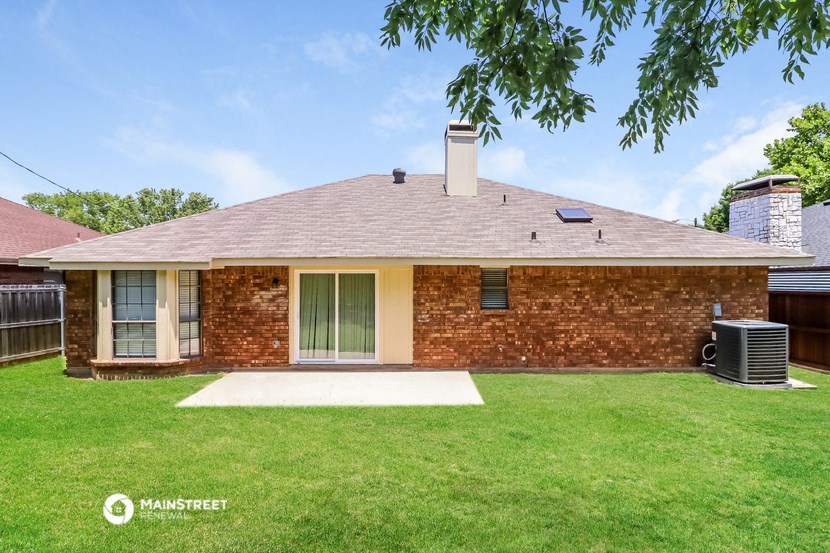 a small brick house with a grassy yard and a roof