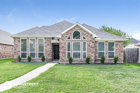 a home with a lawn and a sidewalk in front of it