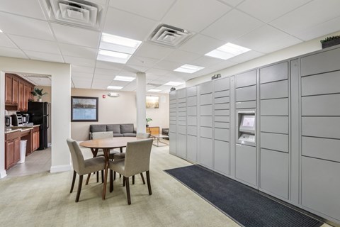 A conference room with a table and chairs and a wall of lockers.