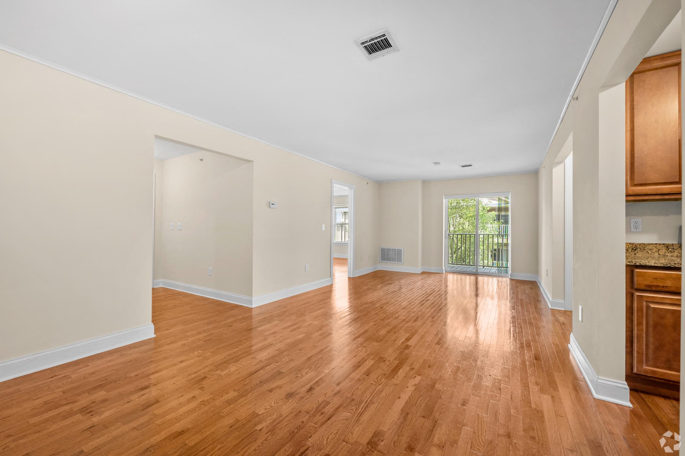 a living room with a hard wood floor and a window