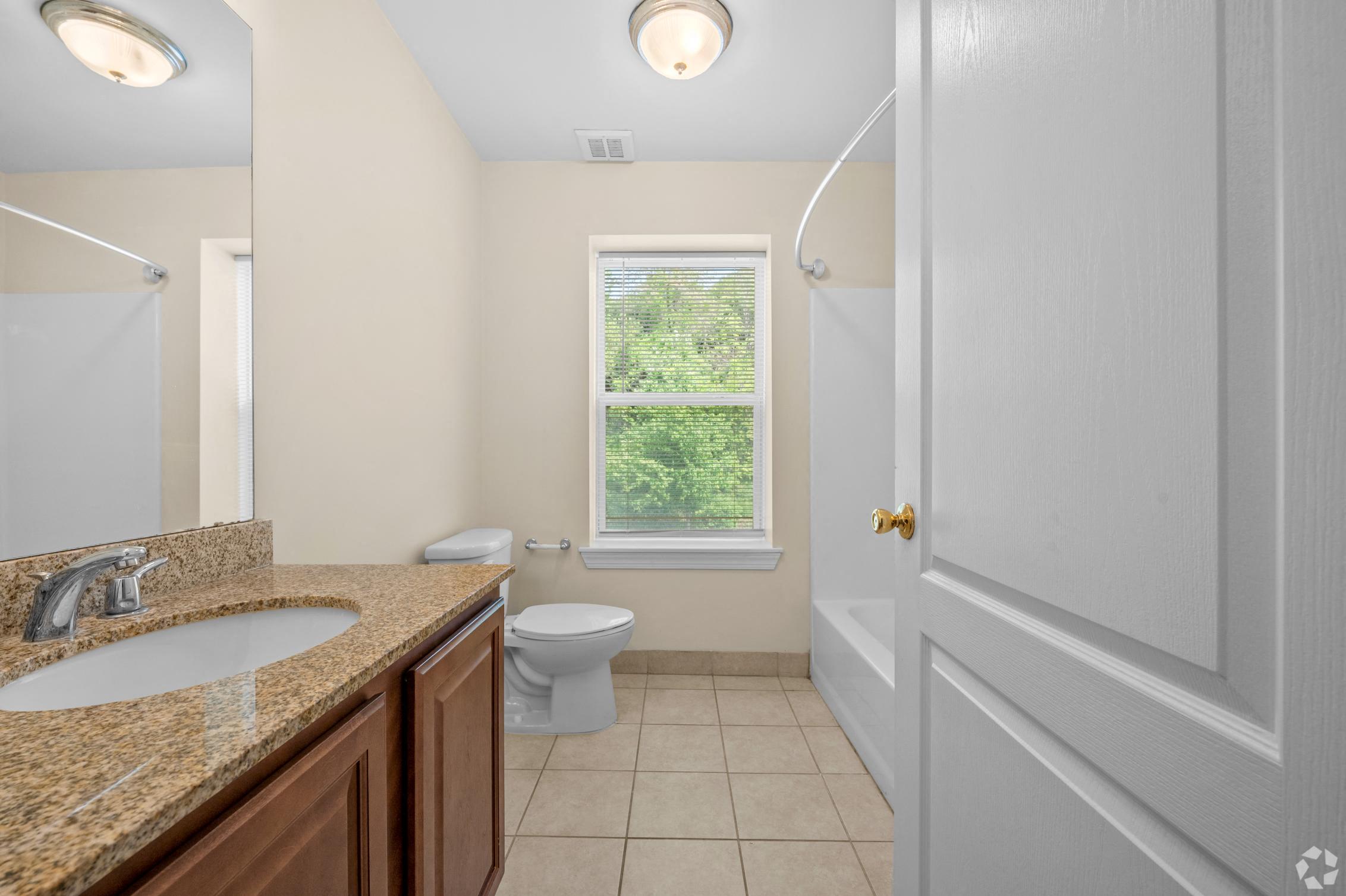 a bathroom with a toilet and a sink and a window