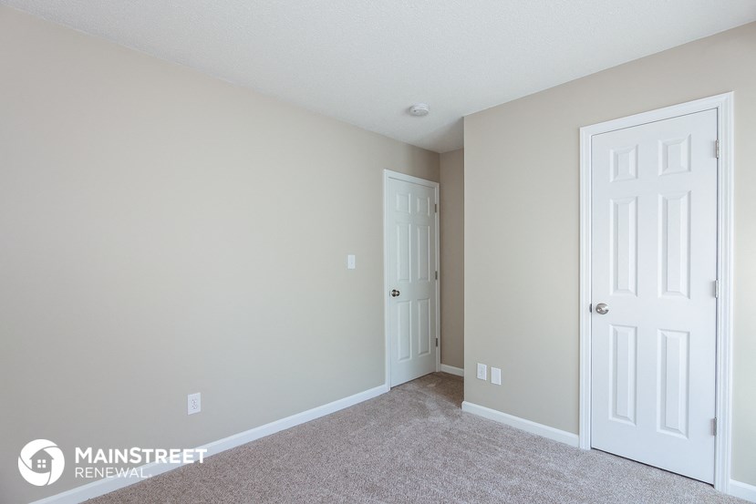a bedroom with two doors and a door to a closet