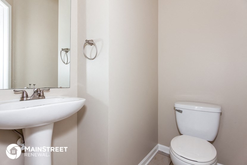 a bathroom with a toilet and a sink and a mirror