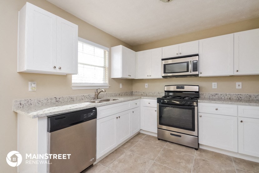 a kitchen with white cabinets and stainless steel appliances