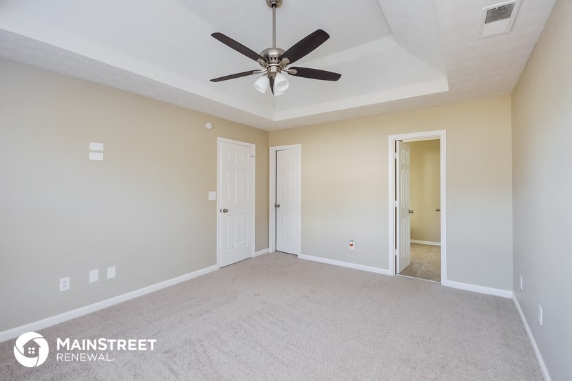the living room of a new home with a ceiling fan