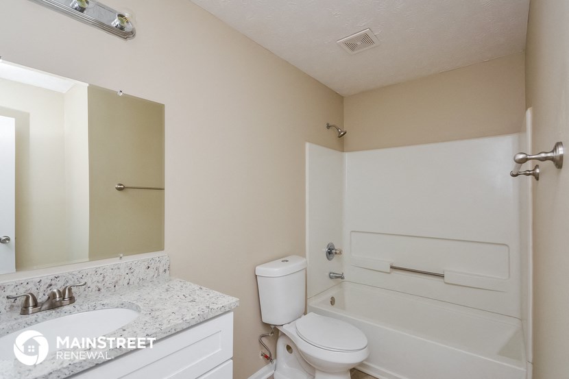 a bathroom with a toilet and a tub and a sink
