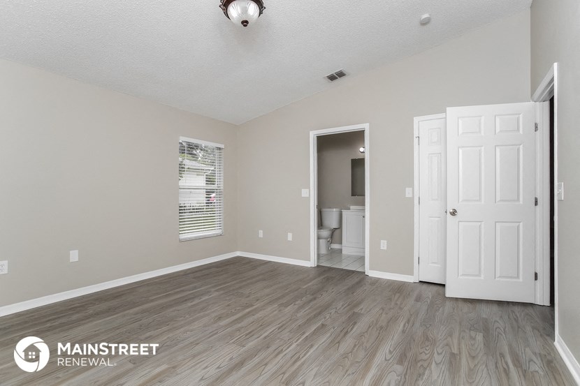 the spacious living room with a white door to the bathroom
