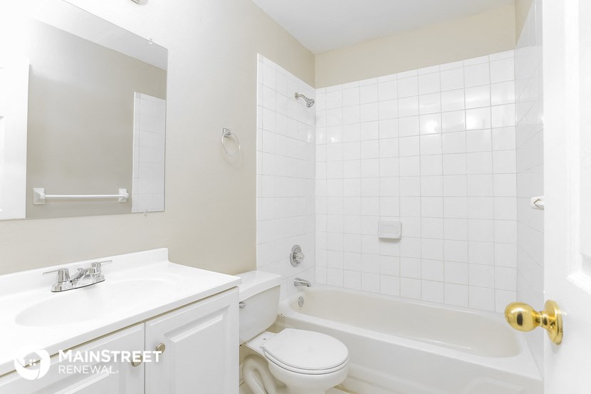 a white bathroom with a tub and a sink and a toilet