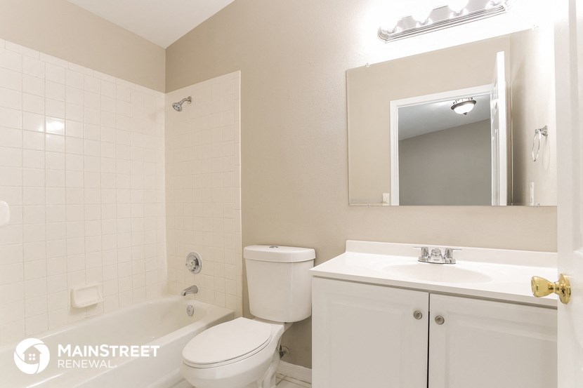 a bathroom with a toilet sink and mirror and a tub