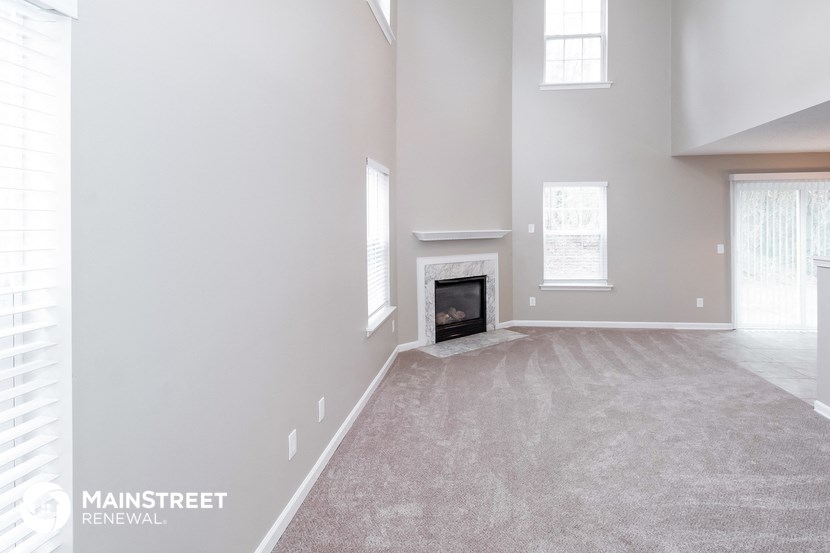 the spacious living room with fireplace and carpeted flooring
