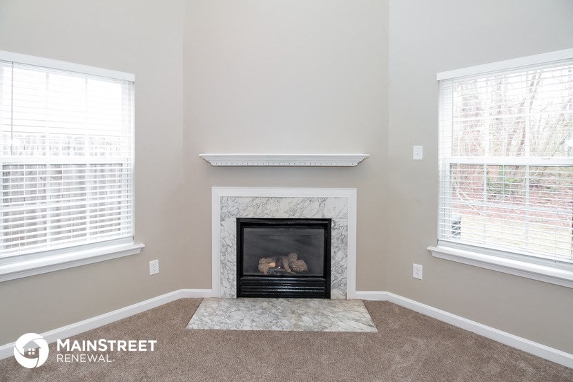 the living room has a fireplace and two windows