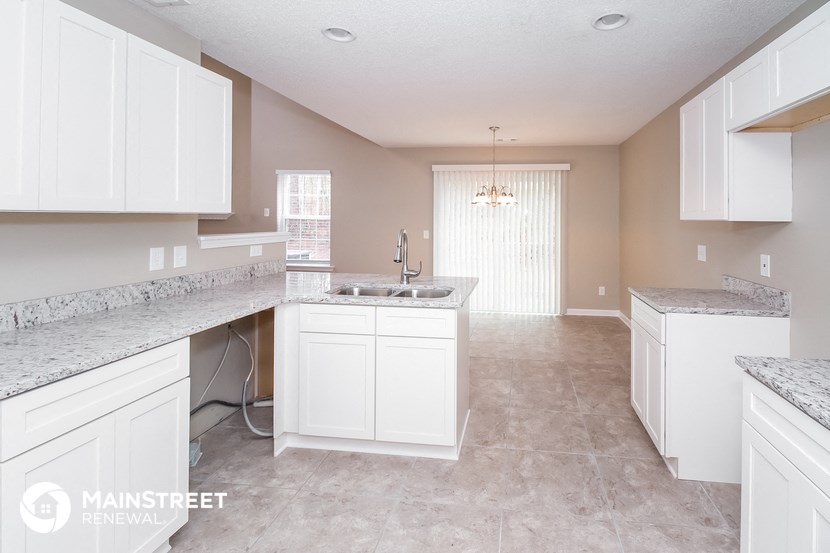 a large kitchen with white cabinets and granite counter tops